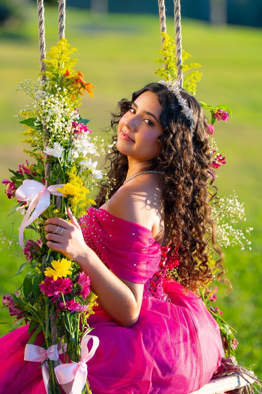 Lara Furtado no balanço de flores, de vestido pink e tiara